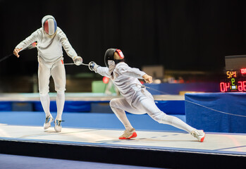  Two fencing athletes fight on professional sports arena