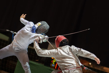  Two fencing athletes fight on professional sports arena