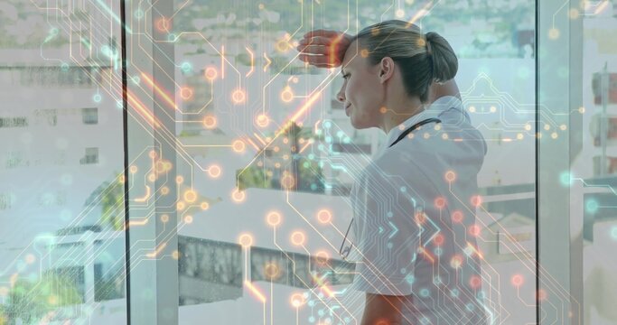 Shielding doctor wearing lab coat, gazing via hospital window over circuit overlay, copy space