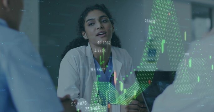 Leading doctor in lab coat briefing medical team at conference table projecting financial charts - Powered by Adobe