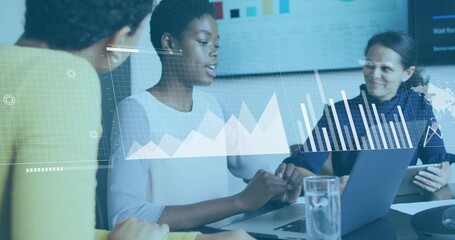 Analyzing data on laptop in conference room with tablet, displaying bar charts on display screen