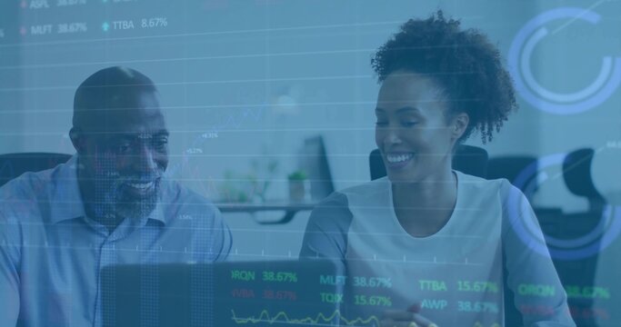 Reviewing financial data on laptop, coworkers in business attire analyzing charts in office - Powered by Adobe