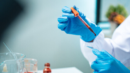Close-up of a scientist in protective gloves placing a drop of blood on a glass slide for...