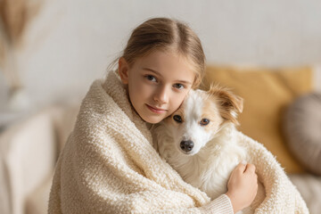 caring girl gently covers her dog with soft blanket in cozy room creating warm atmosphere