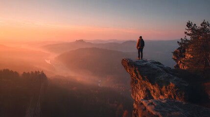 Obraz premium Serenity seeker contemplating sunrise landscape atop cliff edge in natural wonder
