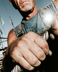 Obraz premium Male construction worker holding a steel rod with both hands. Construction using professional equipment. 