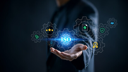 ISO certification concept showing digital gear icons for quality assurance, compliance, and risk management with businessman's hand symbolizing global standardization and corporate control