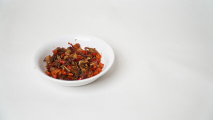 Sambal Embe, a typical Balinese chili sauce, Indonesia, served on a white plate with a white base (isolated white).