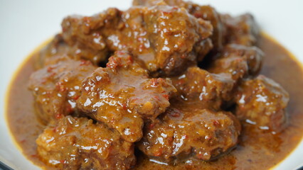 Beef stew is beef stewed with soy sauce and spices, served on a white plate with a white base and background.