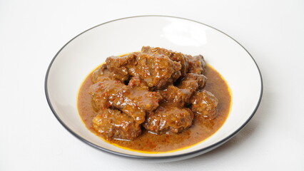 Beef stew is beef stewed with soy sauce and spices, served on a white plate with a white base and background.