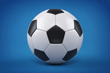Naklejka premium Classic black and white soccer ball on a blue background