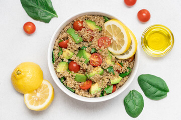 Healthy Quinoa Salad with Avocado and Tomatoes on White Plate