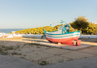Fototapeta premium Conil de la Frontera, Cadiz, Andalusia, Spain. 6 September 2025. Fishing boat display and old stone tower