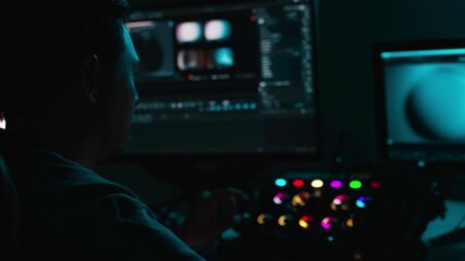 Professional video editor working in dark studio, adjusting color grading and footage on multiple screens, cinematic post production workflow, creative filmmaking technology process
