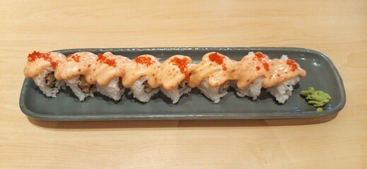 Chicken katsu dynamite roll served on wood table. Food photography presentation