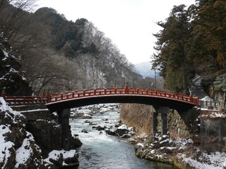 Serene Snowy Landscape with Traditional Red Bridge Over River