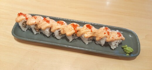 Chicken katsu dynamite roll served on wood table. Food photography presentation