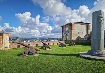 The castle grounds in Dieppe feature a grassy area with antique cannons positioned for defense in...