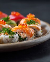 A plate of sushi rolls with colorful toppings and garnishes