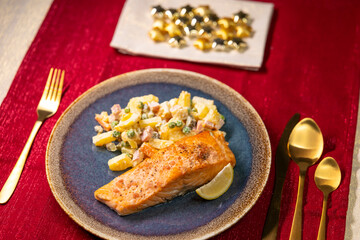 Salmon with Russian Salad and Lemon Slice on Christmas Table Setting