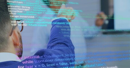 Reviewing code, two engineers collaborating on monitor in meeting room, with code overlays