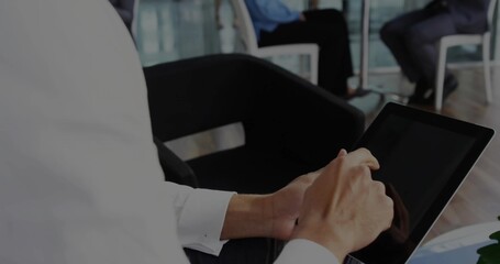 Tapping professional working on tablet computer in office lounge with black armchair, copy space