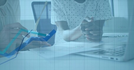 Pointing white-coated doctor with stethoscope at charts with pen in clinic, with patient and laptop