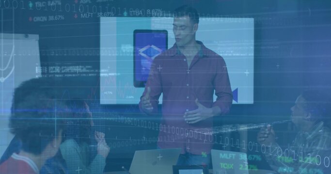 Presenting professional in maroon shirt gesturing toward display in conference room, with charts - Powered by Adobe