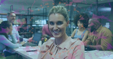 Brainstorming professionals working around table with laptops in office, with network overlay