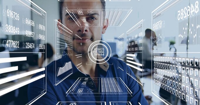 Standing white male wearing navy button-down shirt facing viewer at office, with holographic panels