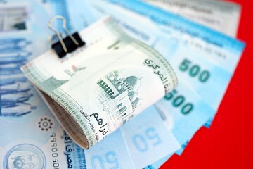 United Arab Emirates dirham money bills in big amount on red. Finance and banking concept