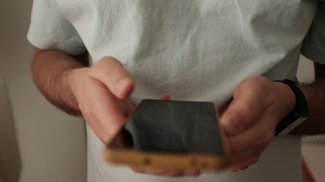 Closeup video of an adult man doom scrolling a smartphone. Addictive behavior. Modern world problem.  Horizontal video.