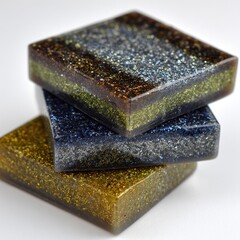 Three square resin coasters, stacked, showcasing layered color transitions and glitter
