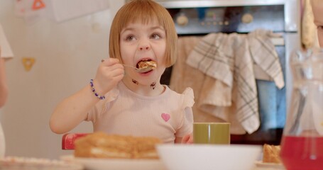 Babies eating. Children nutrition is balance between tasty and healthy. The impact of sweets on a child health, the formation of eating habits, and importance of a balanced diet. Babies eating indoor