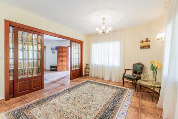 The front hall of the house with furniture and a view of the corridor, with the feeling of bright sunshine outside.