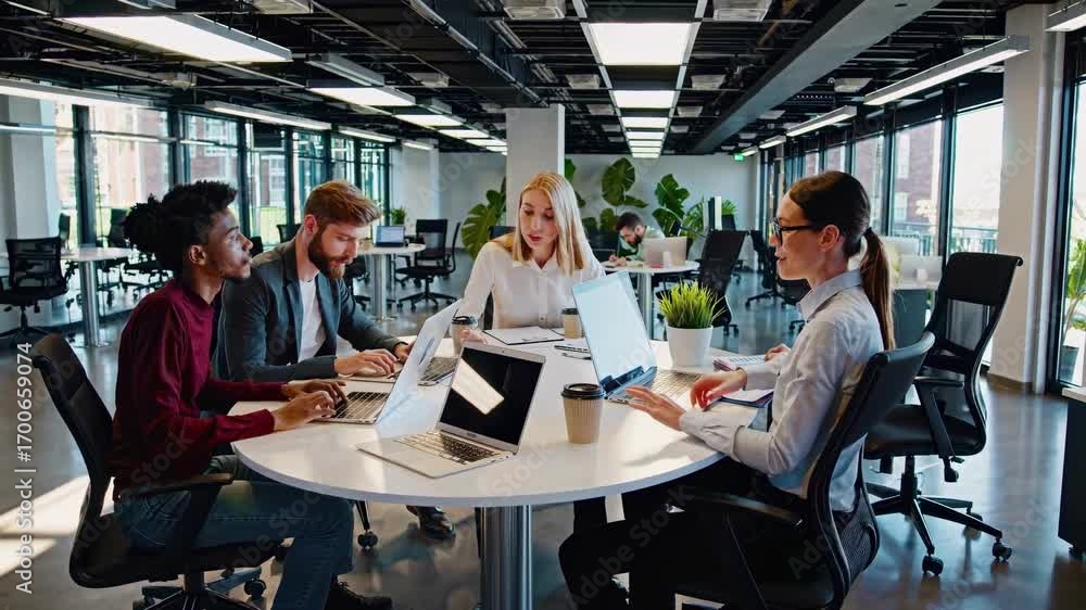 Poster a high-angle video captures a modern office meeting with diverse professionals collaborating around 