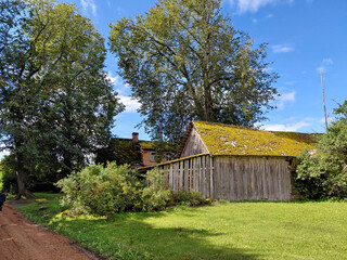 Rustic wooden barn in the countryside - Old shed with a mossy roof