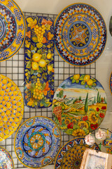 Traditional Italian ceramics with vibrant colors and detailed patterns, showcased in a shop in Assisi, Umbria