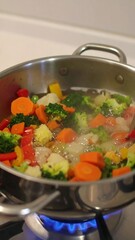 Colorful vegetables simmering in a stainless steel pot over a gas flame