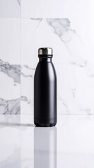 Sleek black water bottle with a silver cap, reflecting on a glossy surface against a marble tile backsplash.
