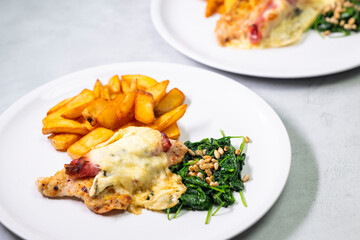 Chicken breast stuffed with ham and cheese, spinach and pine nuts, serving with roasted potatoes
