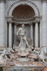 Foto ini menampilkan patung ikonik dari Trevi Fountain (Fontana di Trevi) yang terletak di Roma,...