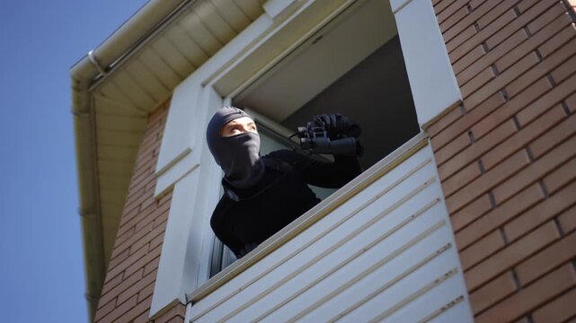 A lone figure peers from an upper window, hinting at covert surveillance or suspicious behavior in the scene