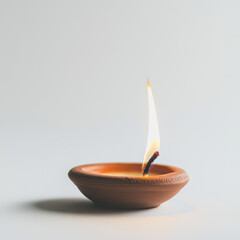 a candle in a clay saucer on a white background