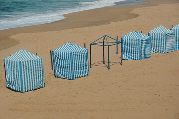 Traditional Blue and White Beach Cabins on Sandy Shore