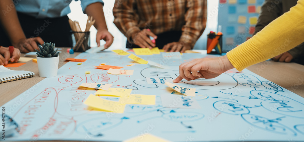 Poster a diverse team engages in a lively brainstorming session, using sticky notes and large paper to gene
