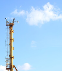 A yellow metal observation tower against a cloudy sky