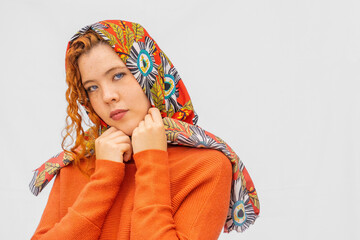 A woman wearing a red and white scarf with a blue eye