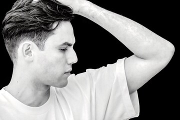 A man with a shaved head and a white shirt is looking up