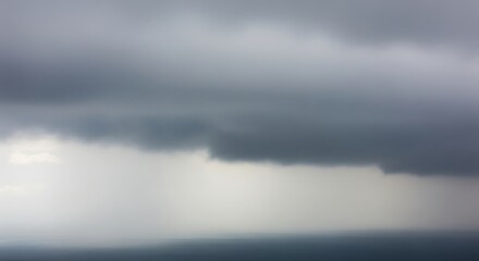 Naklejka premium Dramatic sky with ominous clouds, creating a moody and atmospheric scene above the distant horizon